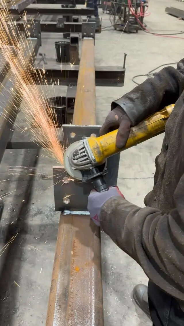 Fabricator grinding a steel connection